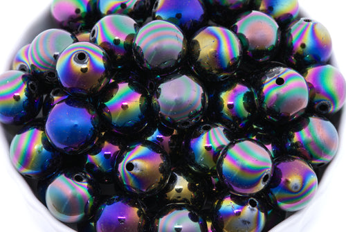 black iridescent beads in a white bowl on a white background