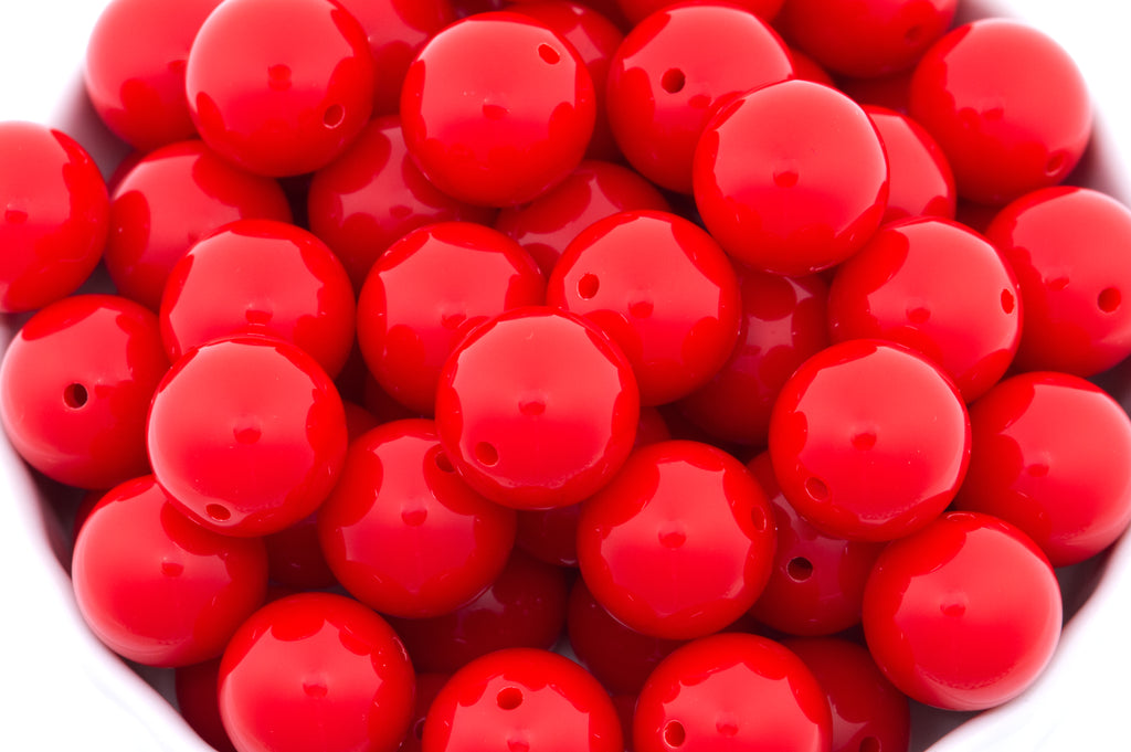 reds beads in a white bowl on a white background