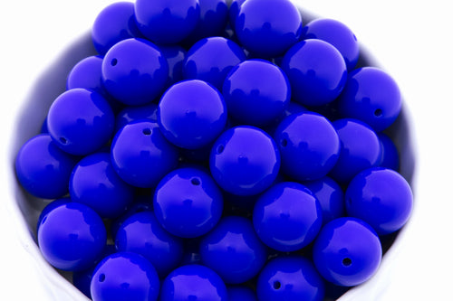 blue beads in a white bowl on a white background