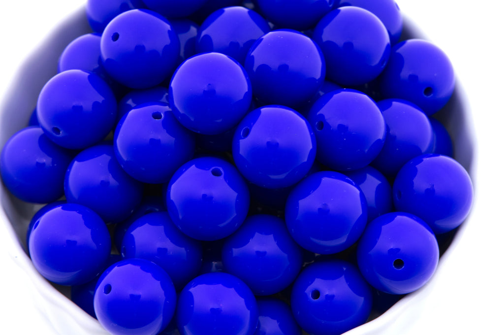 blue beads in a white bowl on a white background