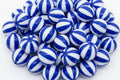 A pile of round  blue and white beach ball striped beads, photographed on a clean white background.