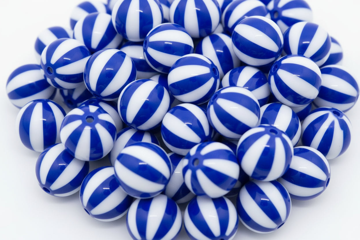 A pile of round  blue and white beach ball striped beads, photographed on a clean white background.