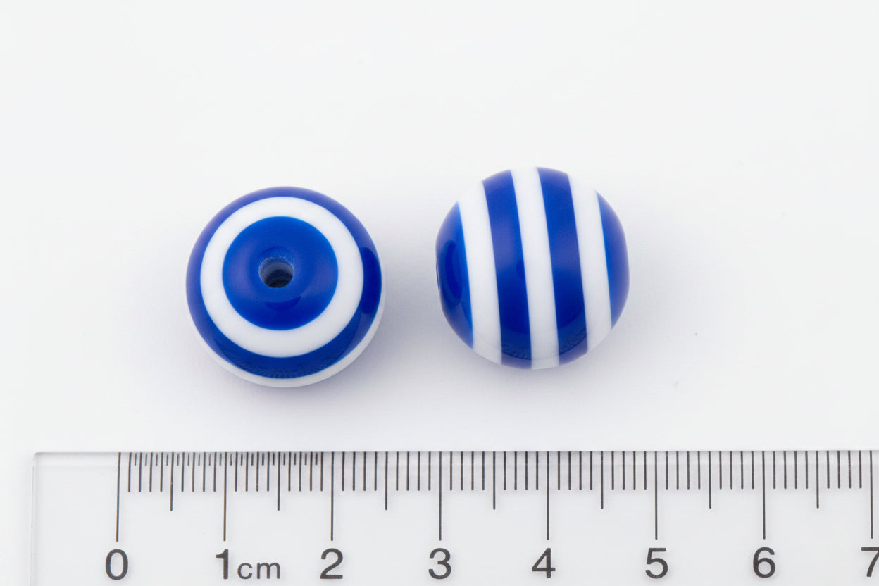 Two round beads with blue and white stripes, shown next to a cm ruler on a black background.