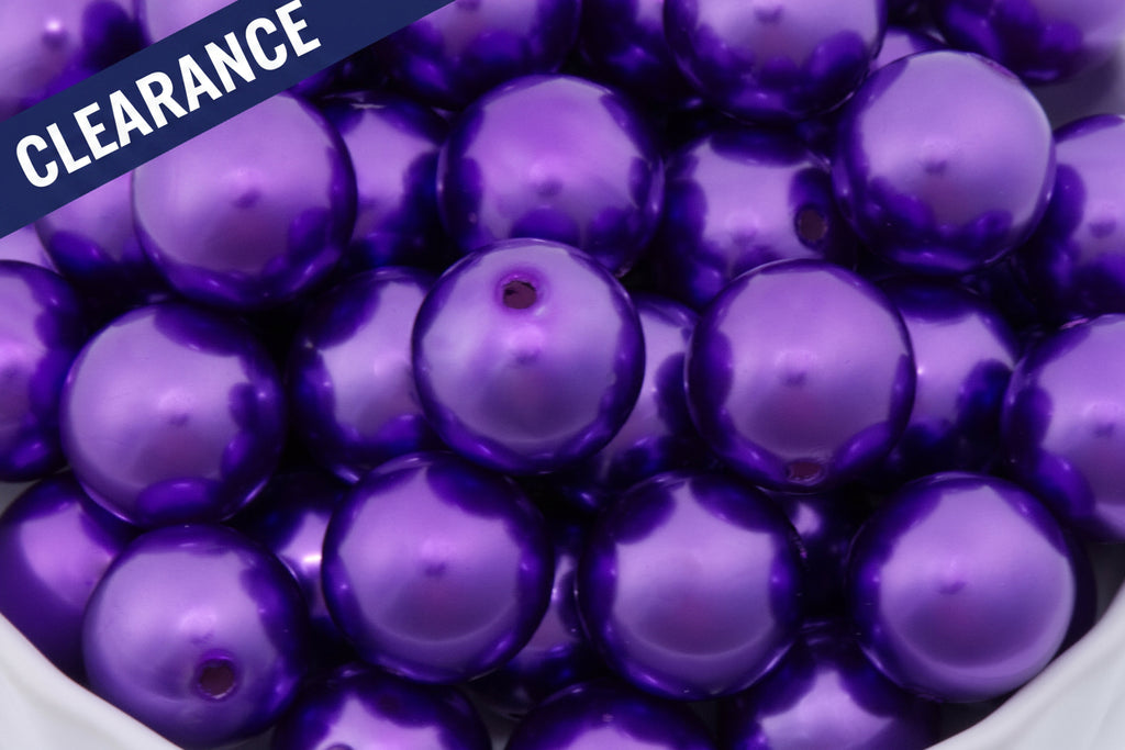 Close-up of purple metallic beads in a white bowl. clearance label in top left corner. 