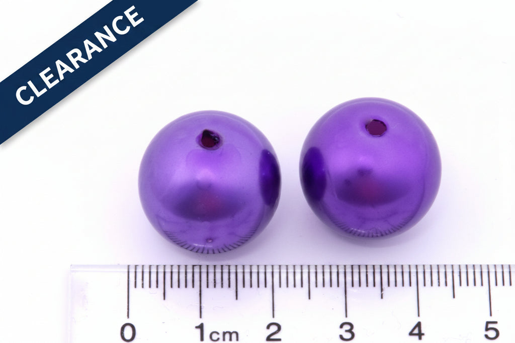 Two purple metallic beads with a ruler for scale on a white background, clearance label in top left corner. 