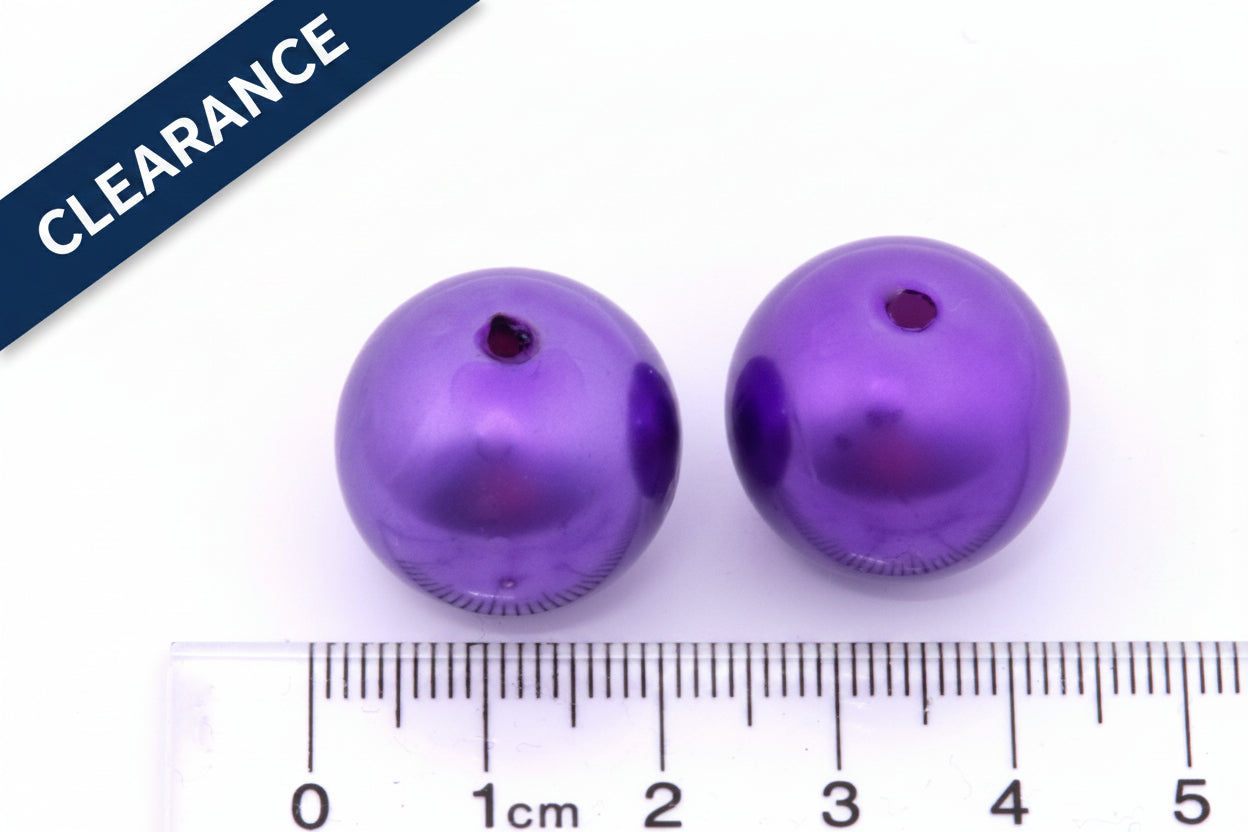 Two purple metallic beads with a ruler for scale on a white background, clearance label in top left corner. 