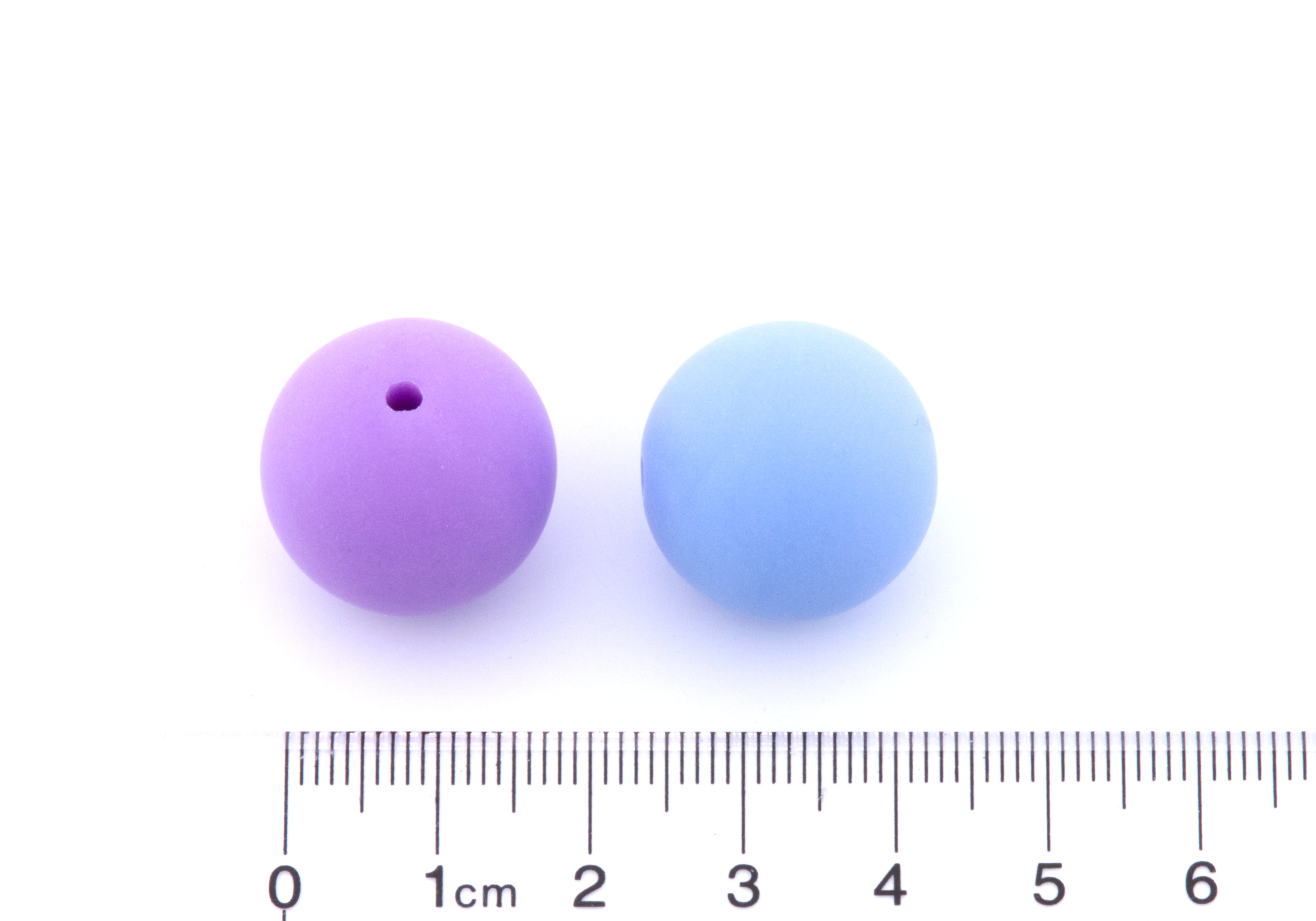 Two small round frosted matte bubblegum beads shown side-by-side above a centimeter ruler for scale on a white background.