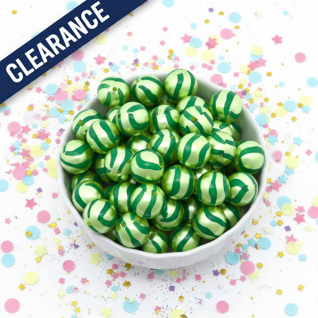green striped metallic beads in a white bowl on a confetti background. clearance label on top left corner. 