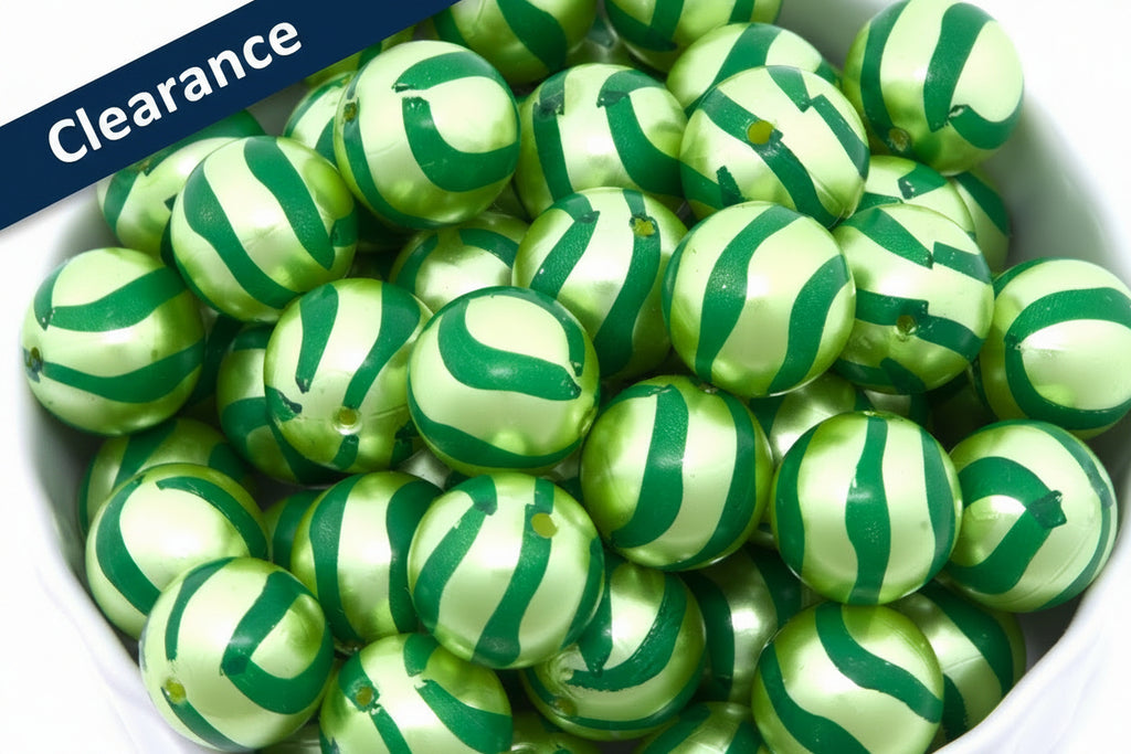close up photo of green striped metallic beads in a white bowl. clearance label in top left corner. 