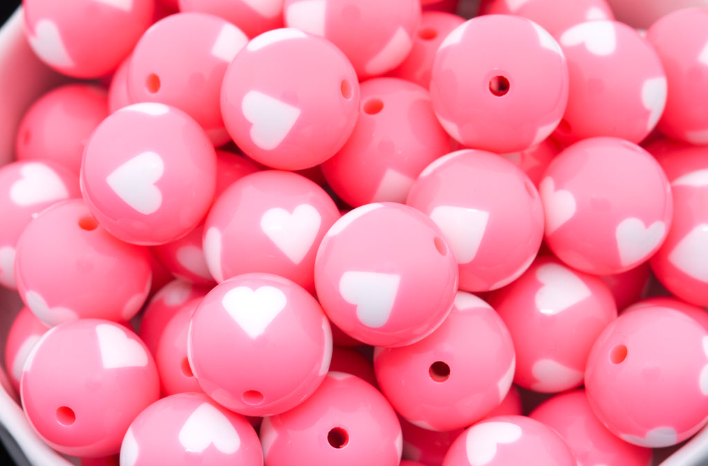 Close-up of pink beads with white heart patterns