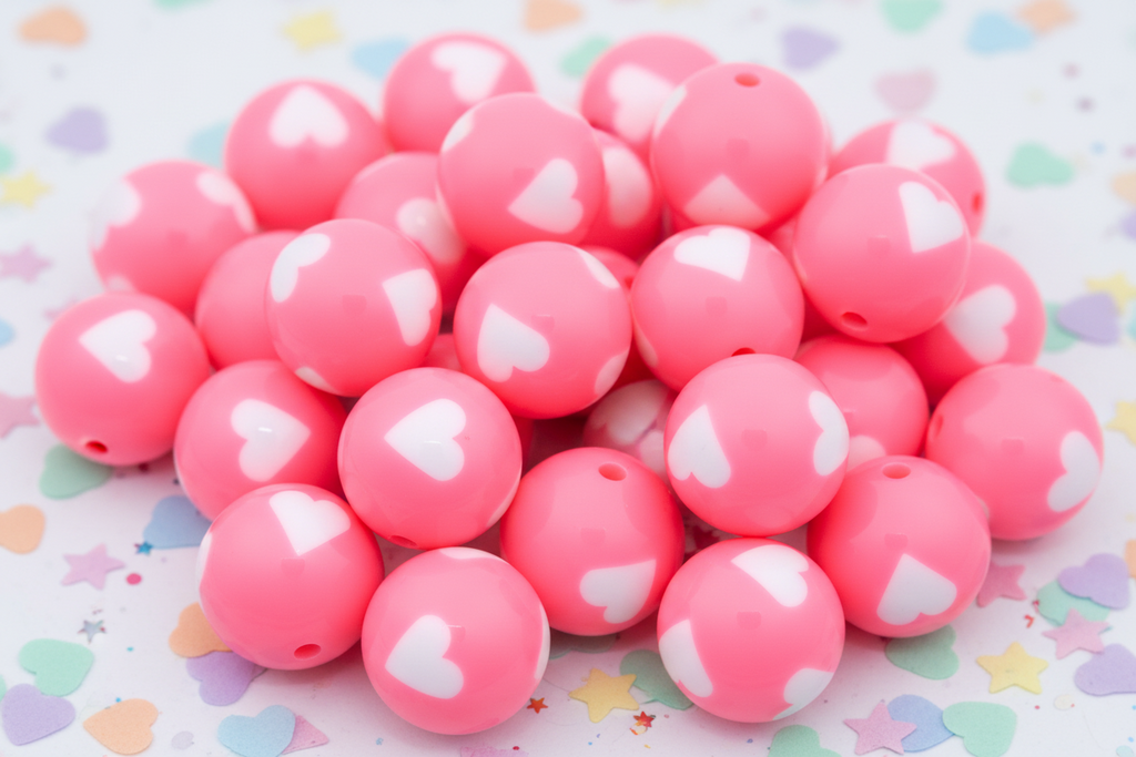 Pink beads with white heart patterns on a colorful star and heart patterned background