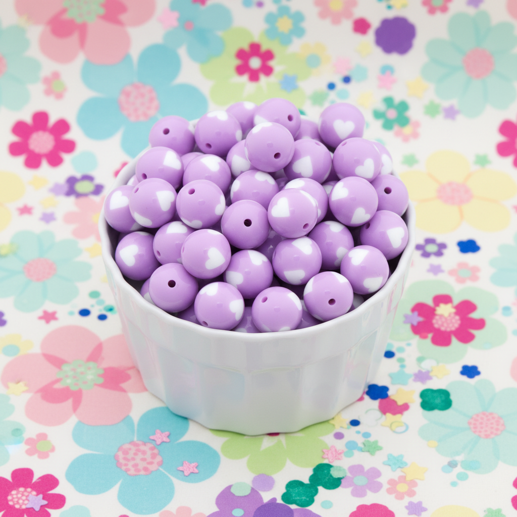 Purple beads with white hearts in a white bowl on a colorful floral background