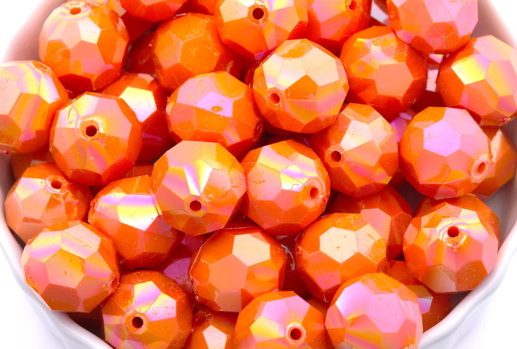 orange faceted beads in a white bowl on a white background