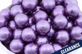 Close-up of metallic purple beads in a white bowl. clearance label on the bottom right corner.