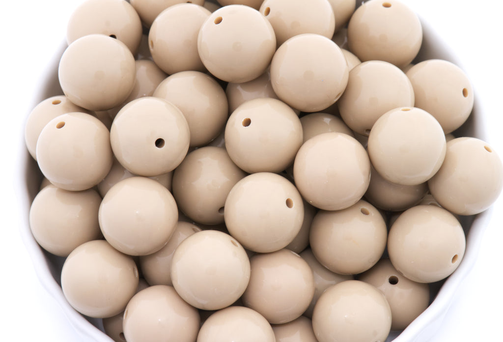 brown beads in a white bowl on a white background