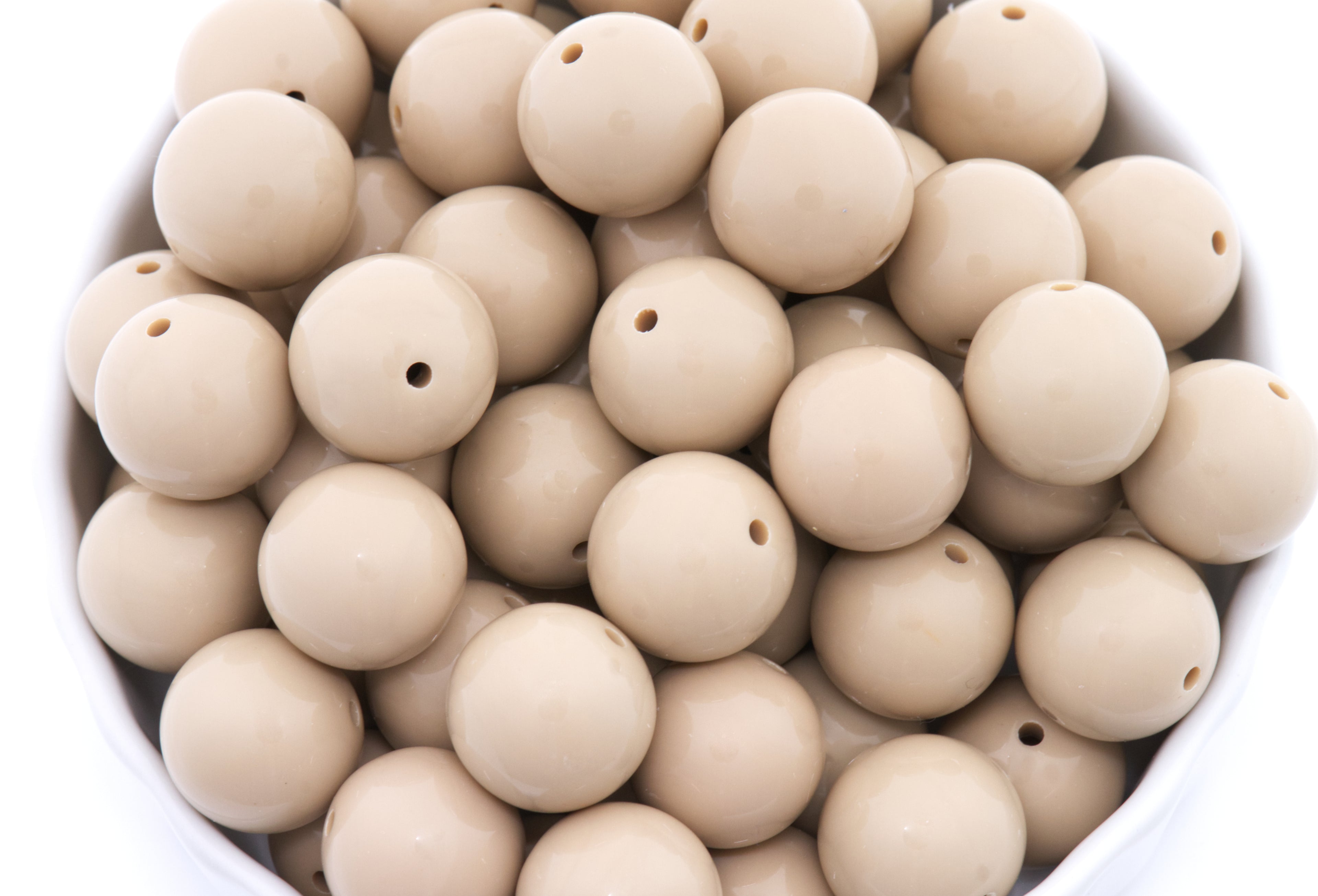 brown beads in a white bowl on a white background