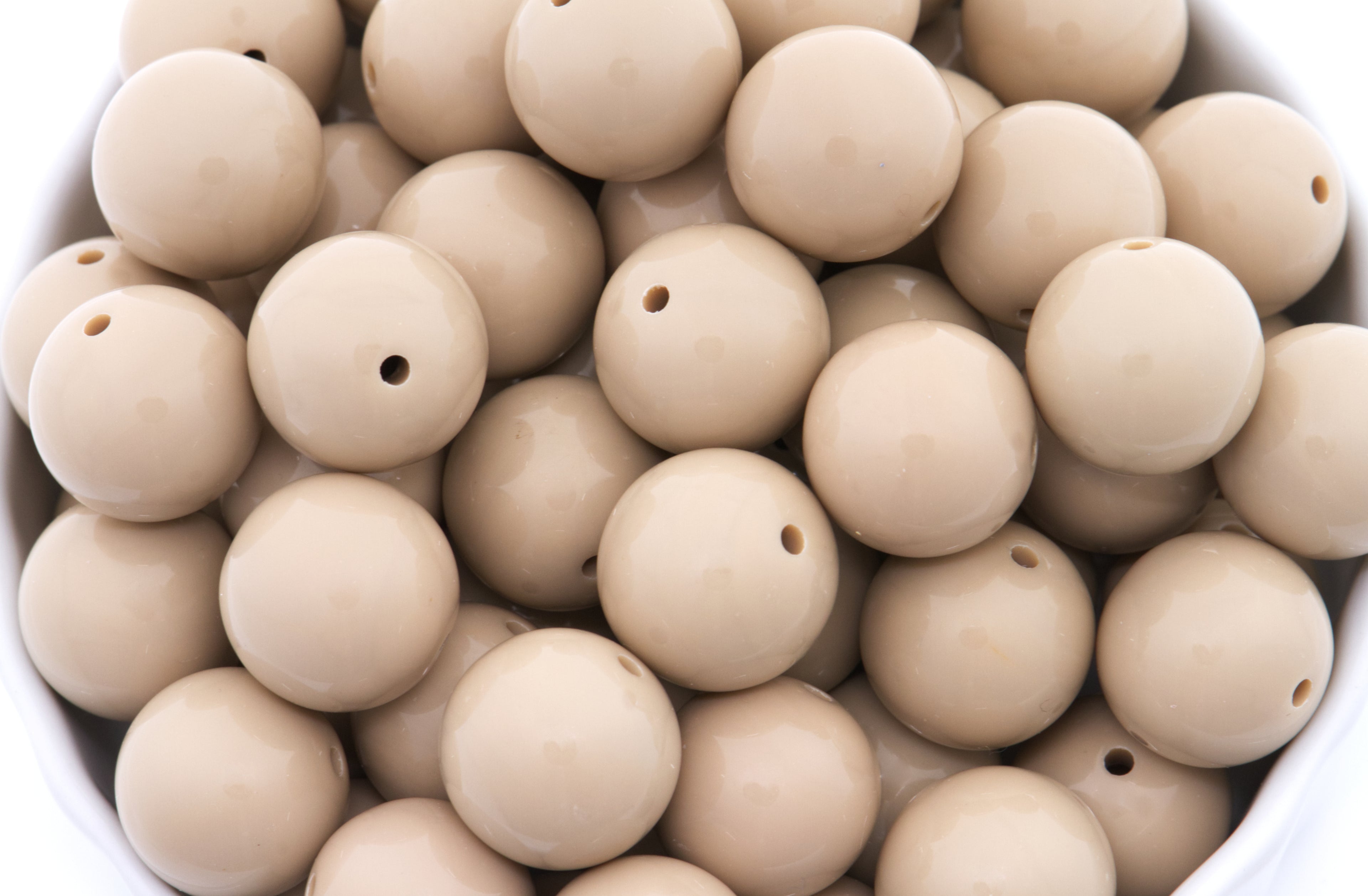 brown beads in a white bowl on a white background