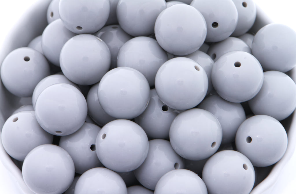 gray beads in a white bowl on a white background 