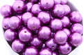 purple bubblegum beads in a white bowl on a white background 