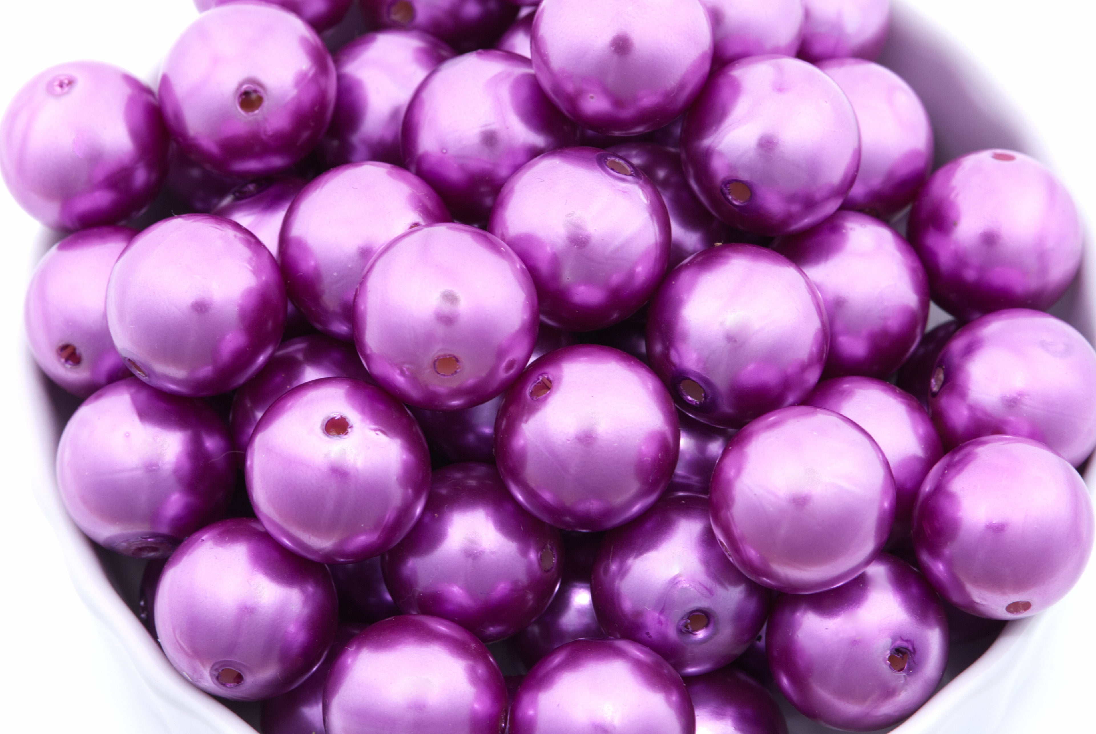 purple bubblegum beads in a white bowl on a white background 