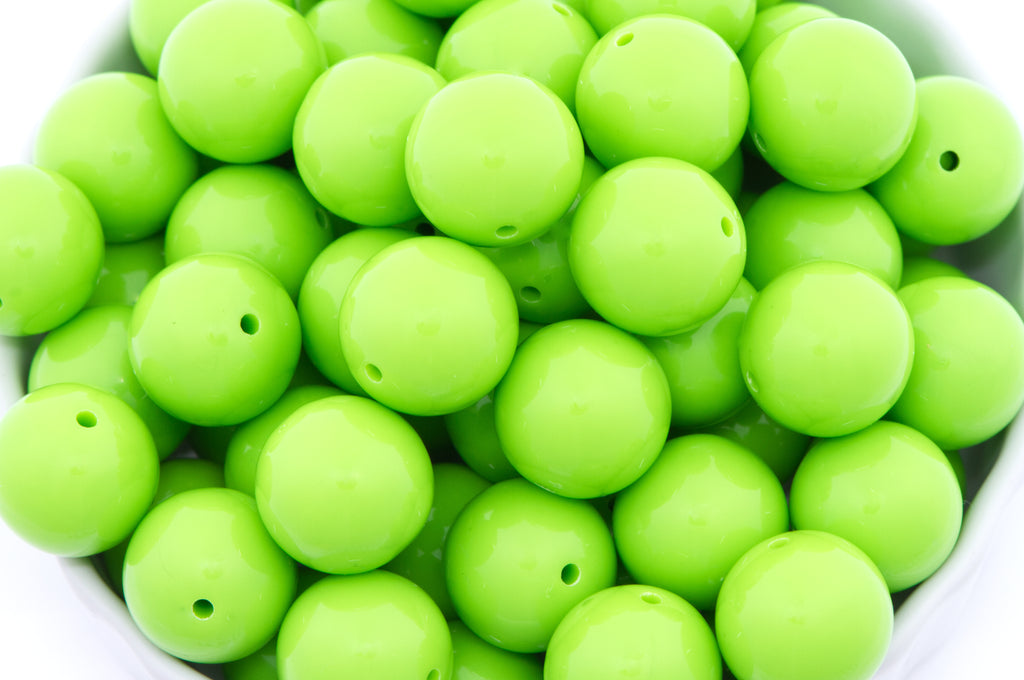 green beads in a white bowl on a white background
