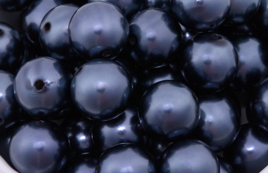 Close-up of dark blue beads with a glossy metallic finish