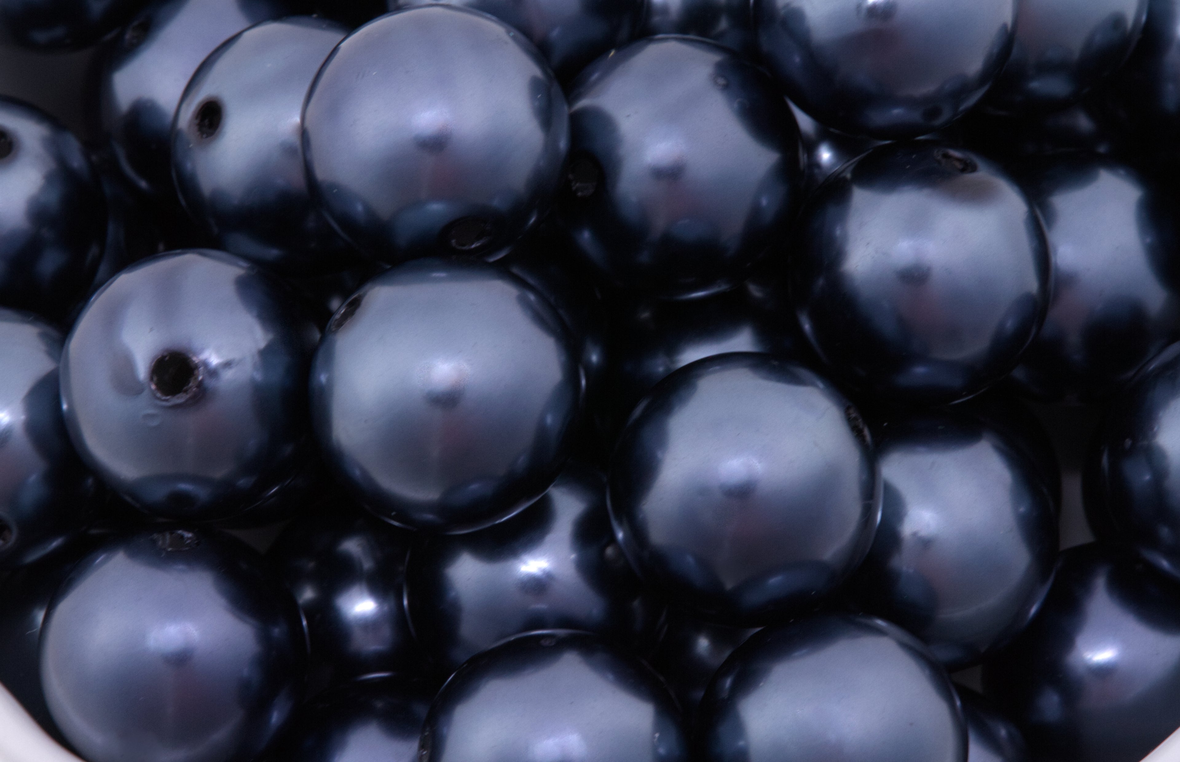 Close-up of dark blue beads with a glossy metallic finish