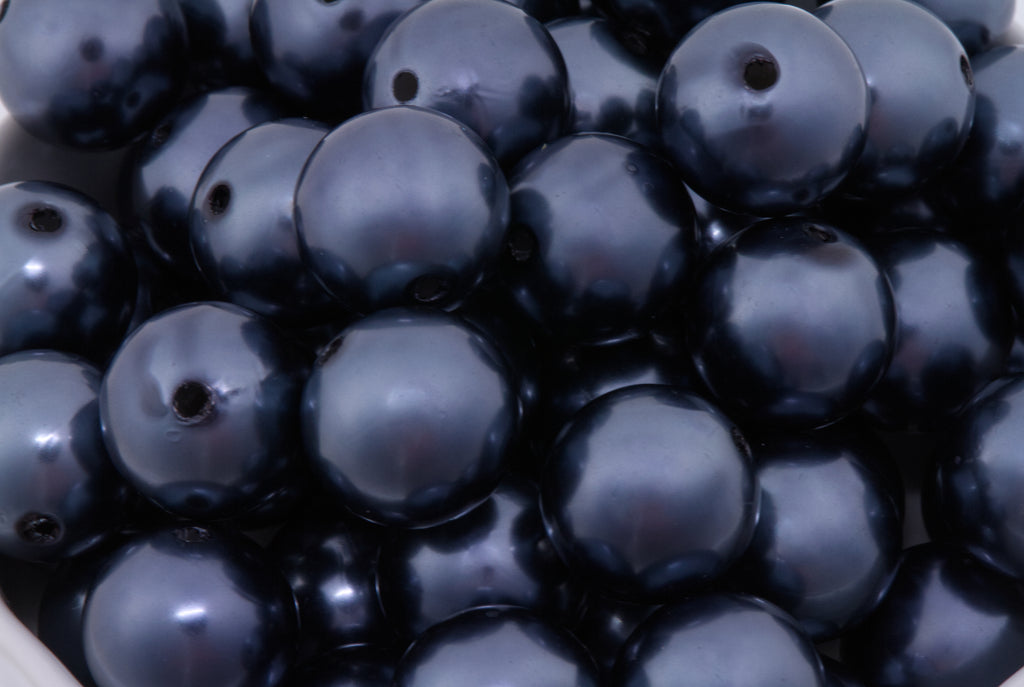 Close-up of dark blue beads with a glossy metallic finish