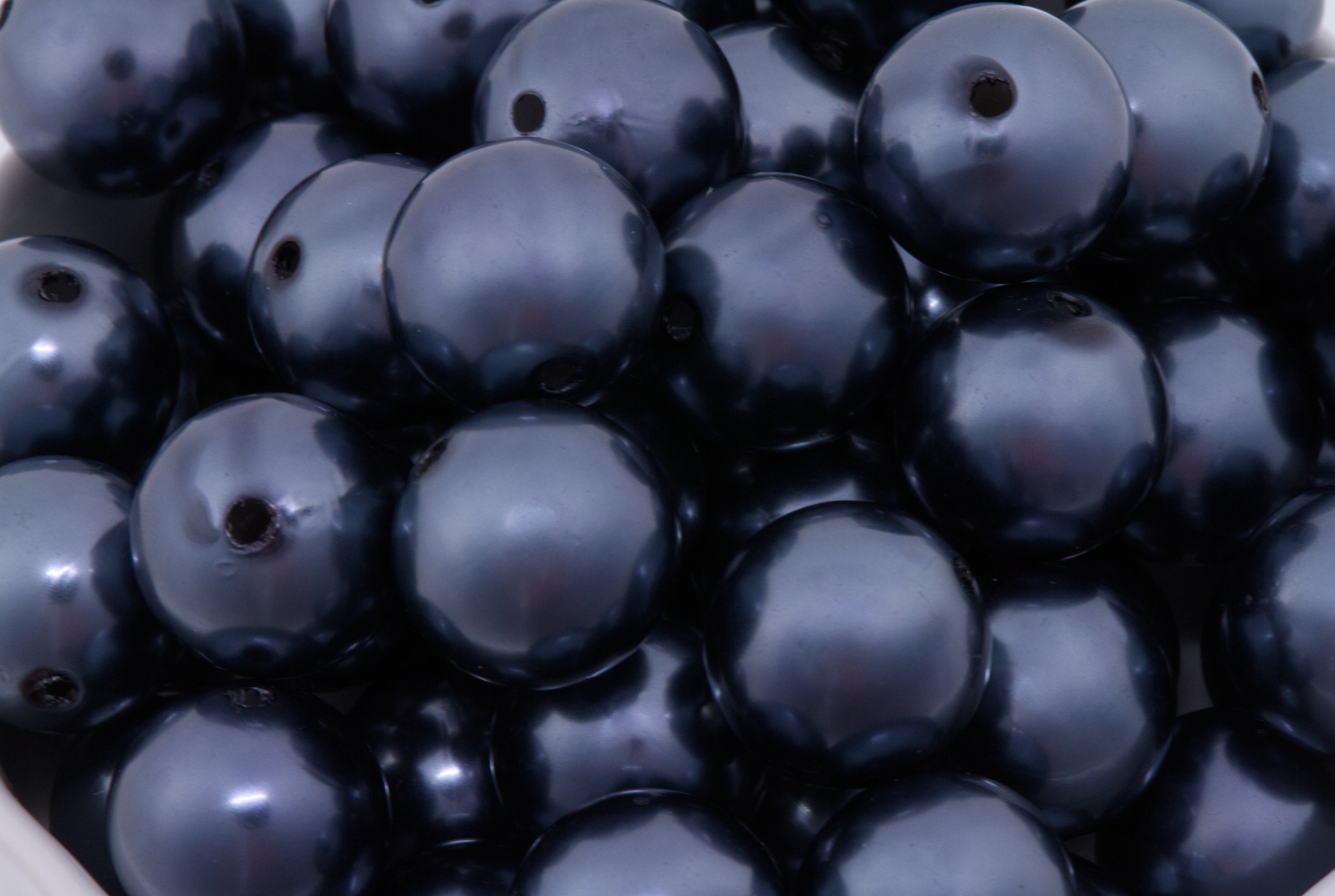 Close-up of dark blue beads with a glossy metallic finish