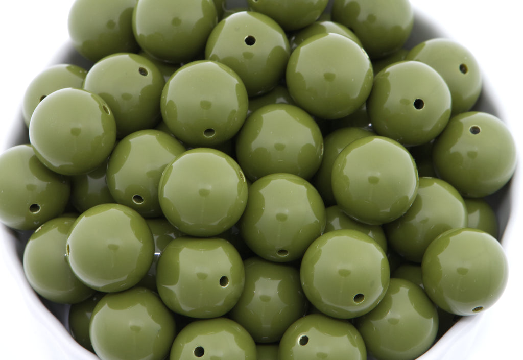 green beads in a white bowl on a white background