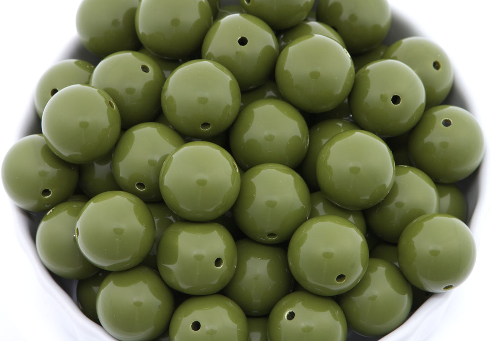Green beads in a white bowl on a white background