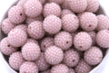 Close-up of pink rhinestone beads in a white bowl