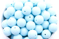 Light blue beads in a white bowl on a white background 