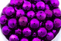 Close-up of metallic purple beads on a white background