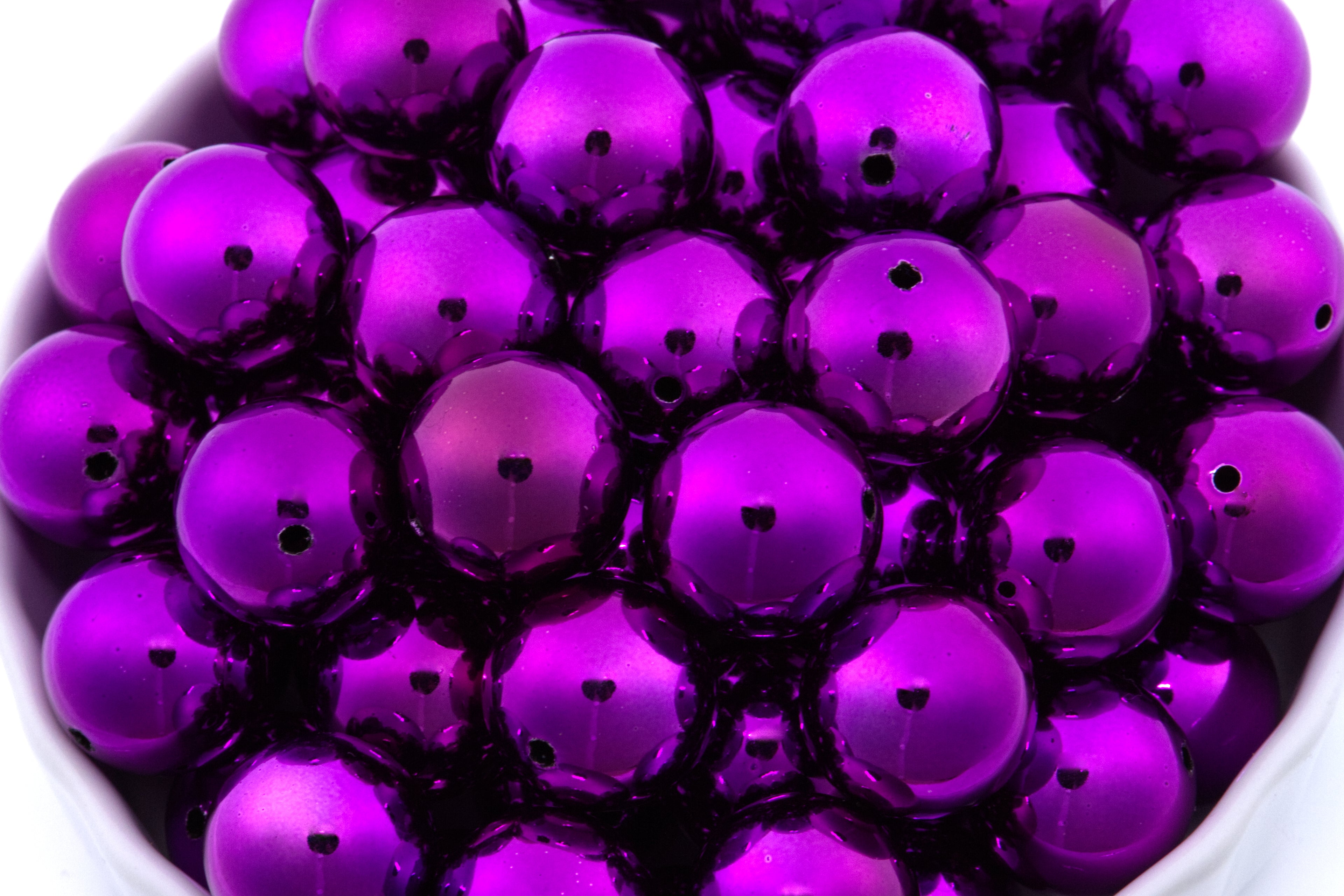 Close-up of metallic purple beads on a white background