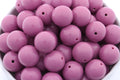 purple beads in a white bowl on a white background