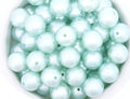 blue bubblegum beads in a white bowl on a white background