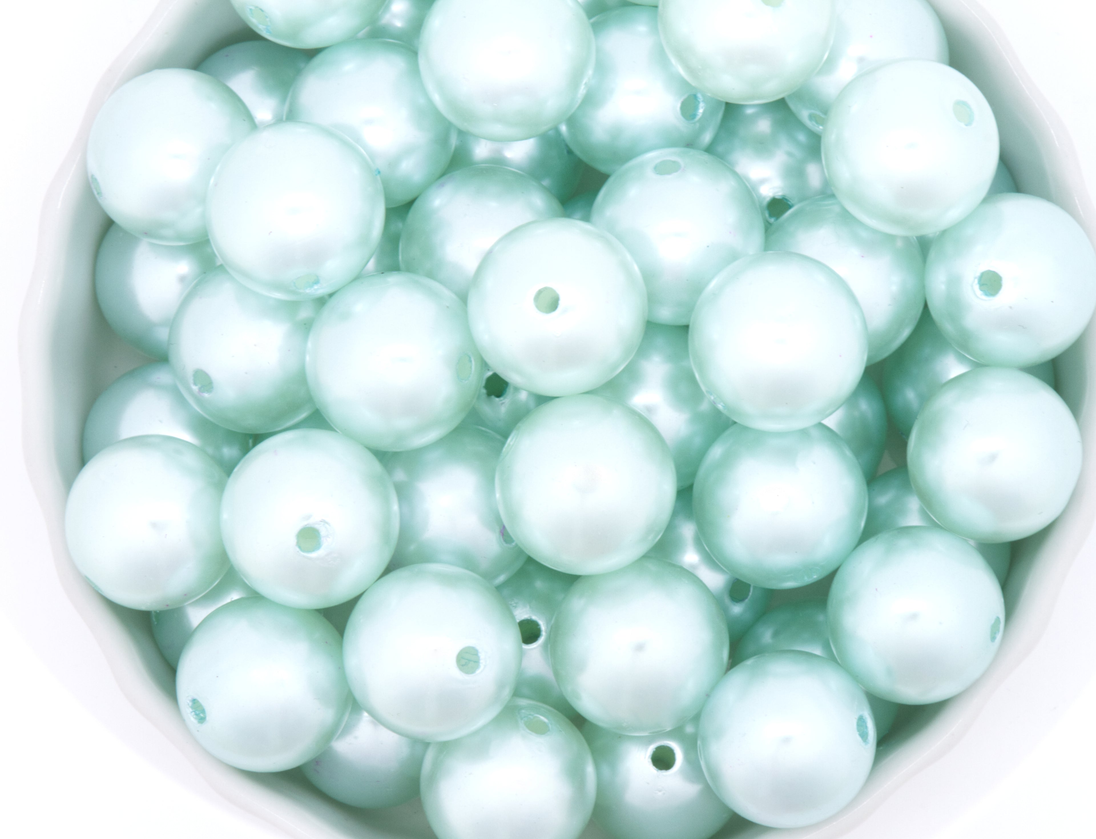 blue bubblegum beads in a white bowl on a white background