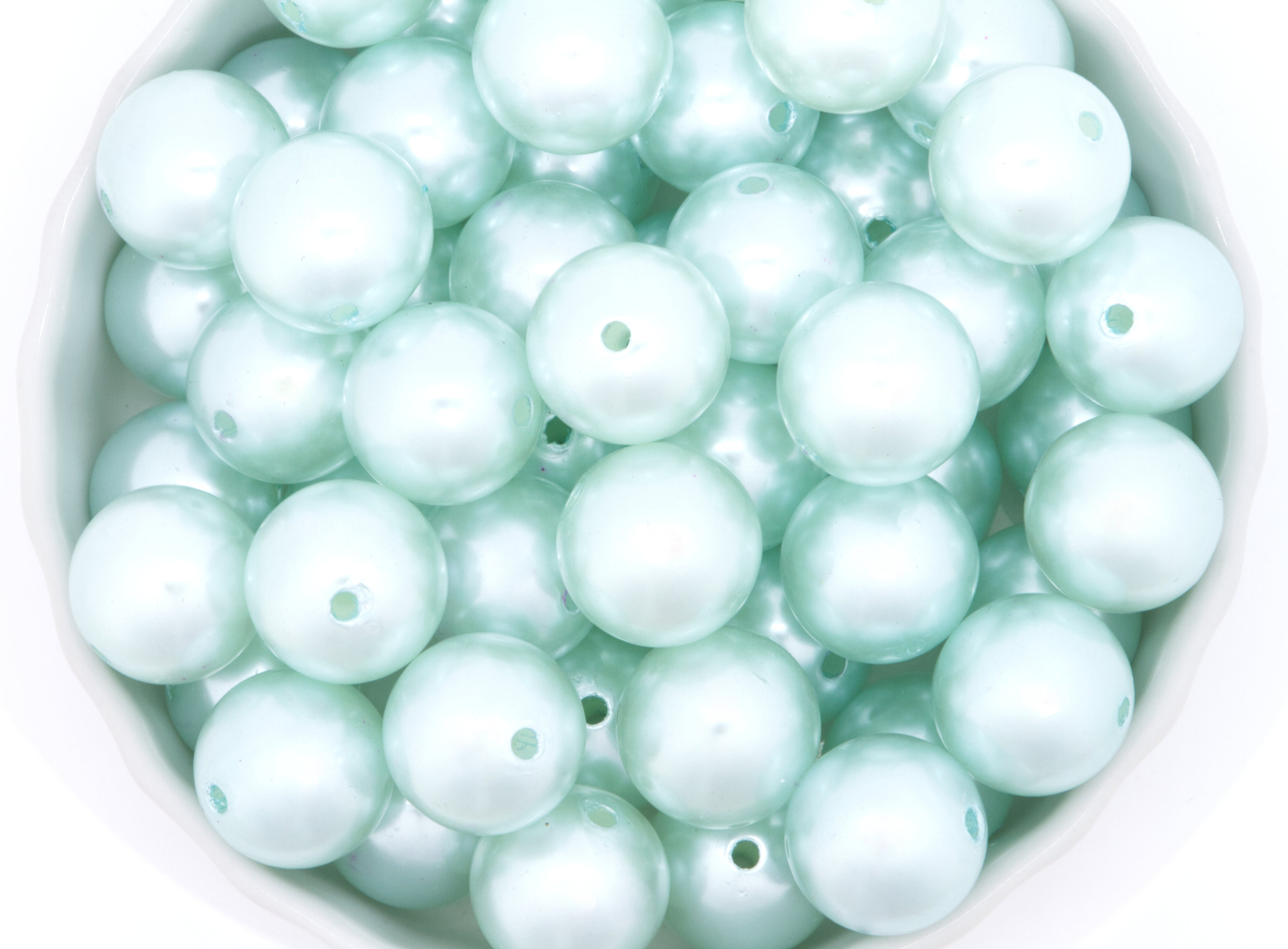blue bubblegum beads in a white bowl on a white background