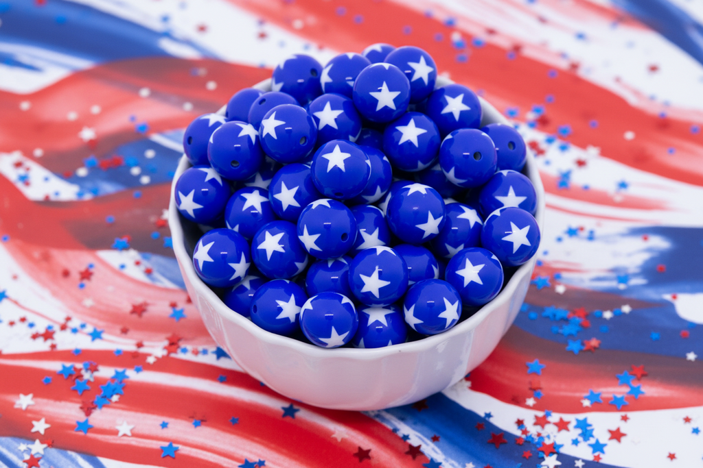 Blue beads with a white star pattern in a white bowl on an American flag background.