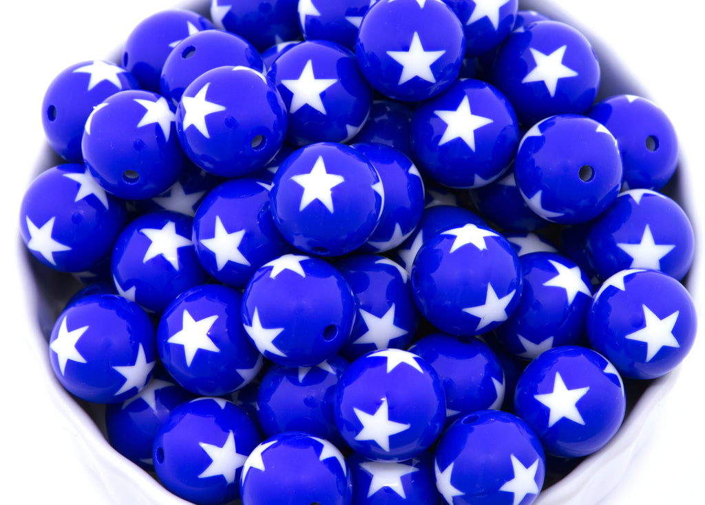 Blue beads with white star patterns in a white bowl