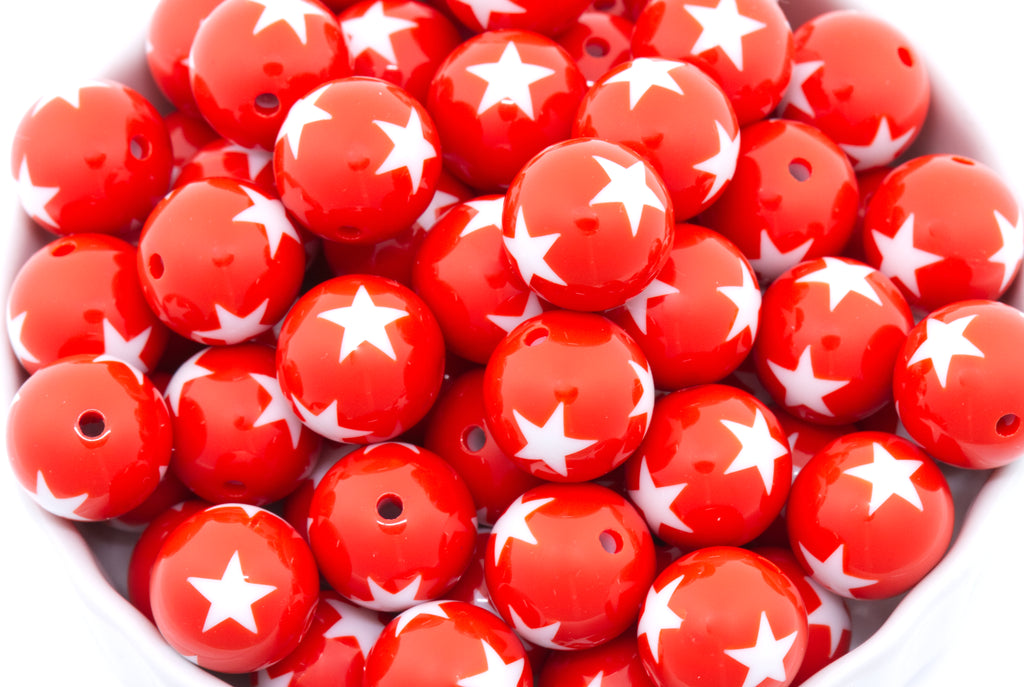 Red beads with white star patterns in a white container