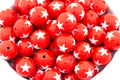 Red beads with white star patterns on a white background