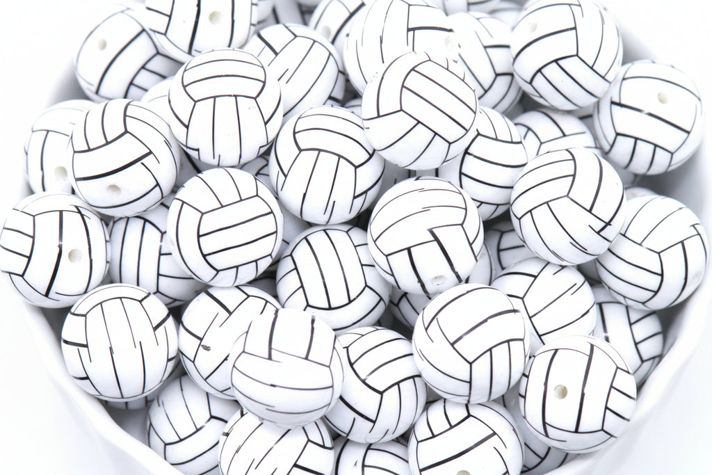 A pile of volleyball bubblegum beads, arranged in a white bowl against a white background.