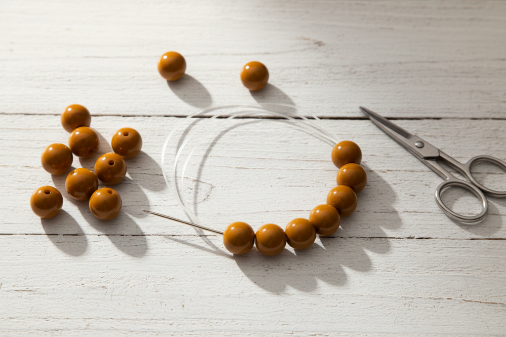 brown beads on a clear string with scissors on a light wooden surface
