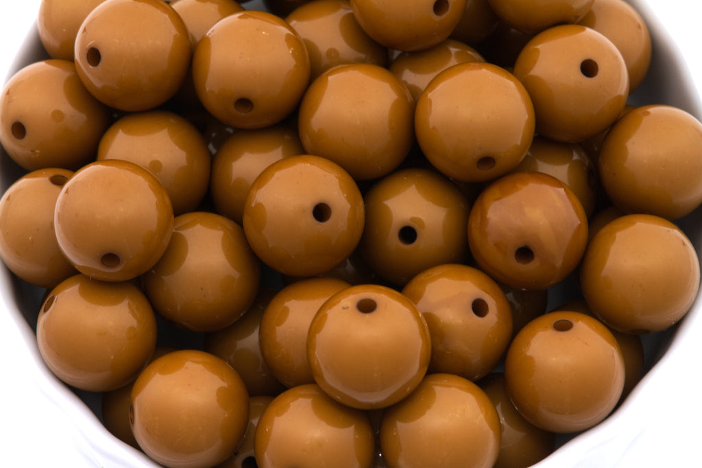 brown beads in white bowl on a white background
