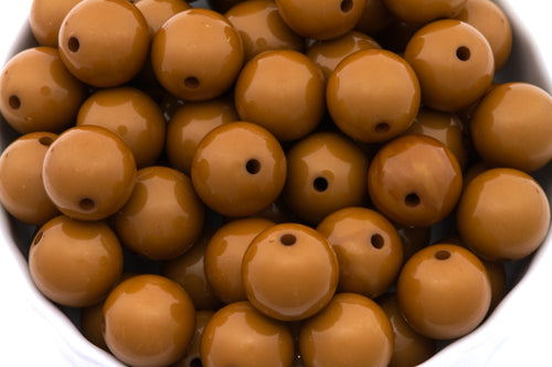 brown beads in white bowl on a white background