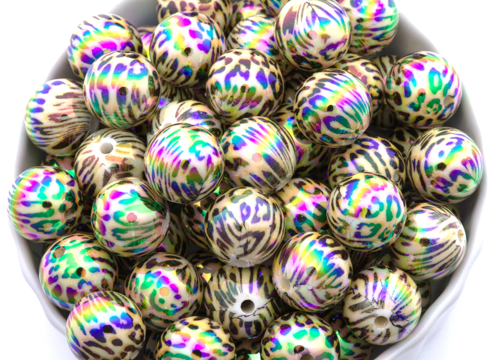 cheetah print iridescent round beads in a white bowl with a white background