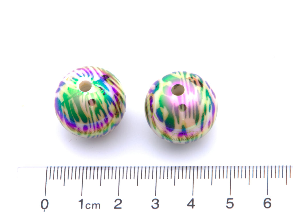 two cheetah print beads with a ruler for scale on a white background