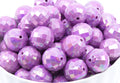 Purple faceted beads in a white bowl on a white background